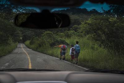Migrants walk through Highway México 307 on Oct. 21 near Palenque, Chiapas. The highway is also known by the locals as 'El gran corredor del pacífico del migrante,