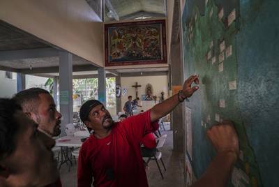 Honduran migrant Miguel Alvarado, 36, right, explains to other migrants the different routes people take in order to go to the United States at the migrant shelter Casa del Caminante Jtatic Samuel Ruiz García near Palenque, Chiapas on Oct. 20. Miguel plans to work in the U.S. to be able to support his three kids that he left behind. He had heard about the migrant caravan that is currently traversing México, but he decided not to join it because he is afraid they will soon be stopped. Miguel believes it is faster to travel in small groups by going around the migrant caravan.