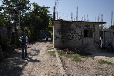 More than 50 migrants, all Honduran with the exception of one Guatemalan, walk to the nearest train station on Oct. 26, 2018, near Palenque, Chiapas. The graffiti reads, 